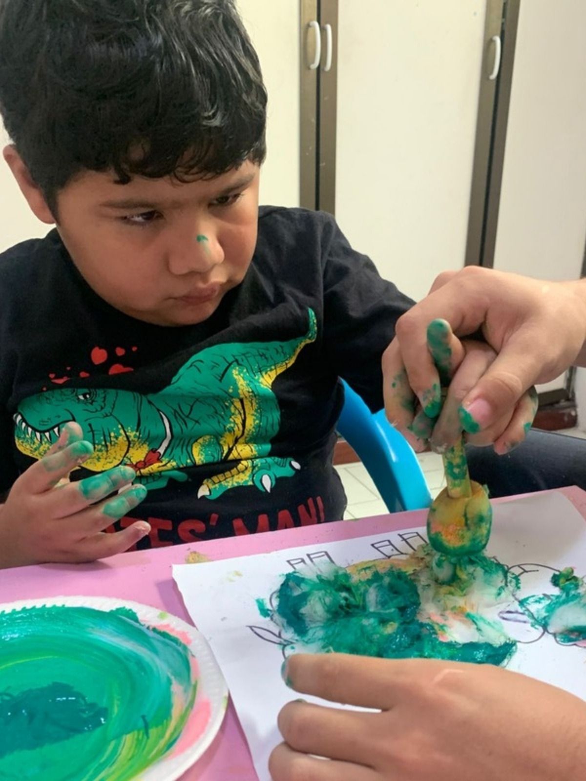 Niño pintando junto a su terapeuta